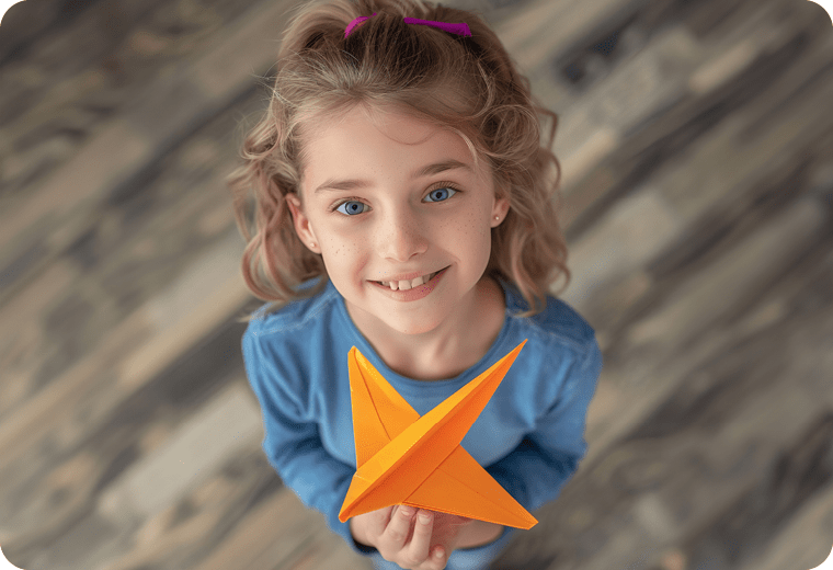 girl holding orange paper plane
