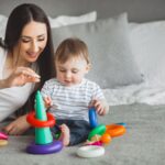 ypung mother playing blocks with her baby